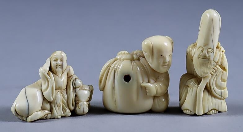 A Japanese Carved Ivory Netsuke of a Man and...