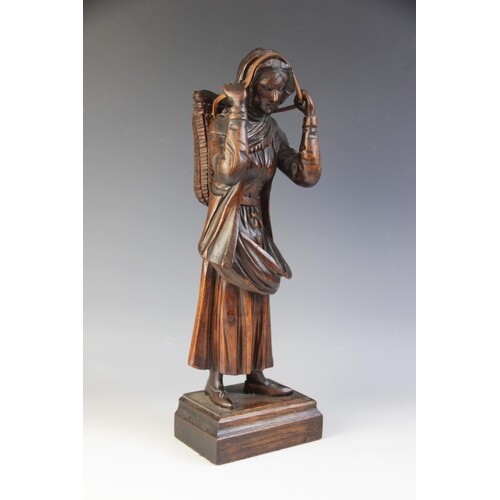 A Northern European folk art carved figure of a fisher woman...