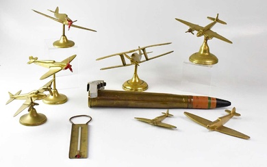A brass model of a Spitfire on stand to spreading...