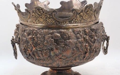 A large Victorian silver plated Monteith bowl, designed with twin handles and raised on a circular foot, the shaped rim of the removable liner cast with grotesque masks, the body of the bowl decorated with various scenes including a Bacchanalian...