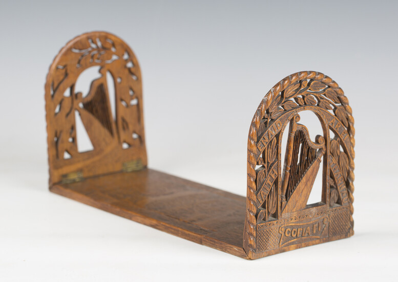 A late 19th century Irish carved oak extending bookstand, each end finely carved with a harp and ins