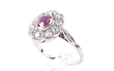 A mid 20th century platinum, ruby and diamond oval cluster ring.