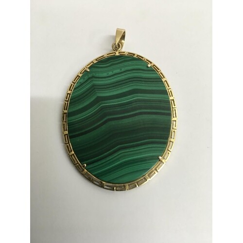 A oval malachite pendant surrounded with a 14 k gold mount ....