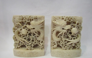 A pair of Chinese carved soapstone bookends, dragons chasing...