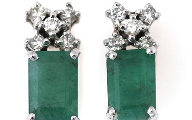 A pair of ear pendants each set with an emerald-cut emerald weighing...