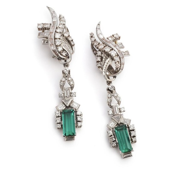 A pair of emerald and diamond ear pendants each set with a Columbian baguette-cut emerald weighing a total of app. 4.00 ct. flanked by a fancy-cut and numerous single-, brilliant-, trapeze- and baguette-cut diamonds weighing a total of app. 3.00 ct...
