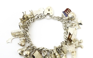 A silver charm bracelet with various silver, white metal and...