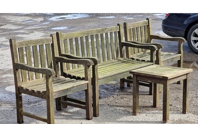 A weathered teak garden suite with slatted seats and backs t...
