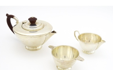 An Art Deco silver three piece tea set comprising teapot, su...