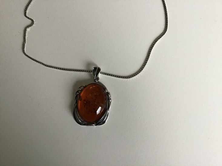 An amber necklace with pendant set with cabochon-cut amber, mounted in sterling silver. Necklace L. 42 cm. Pendant H. 4.8 cm. W. 3 cm.
