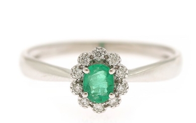 An emerald and diamond ring set with an emerald weighing app. 0.25 ct. encircled by ten diamonds, totalling app. 0.09 ct., mounted in 18k white gold. Size 54.