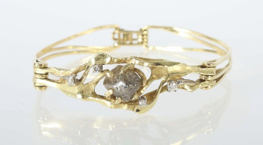 Bracelet from around 1984, jeweller Maar/Radolfzell, yellow gold 750, handcrafted/unique, bracelet made of 3 curved, rustic forged elements, openworked, the middle piece set with a large rough diamond (ca. 5,2 ct) and 4 diamonds (total ca. 0,17 ct)...