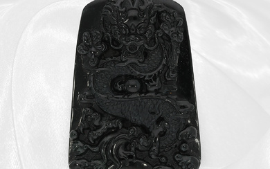 Jade: carved plaque of black jade, very fine quality, dragon motif, with certificate
