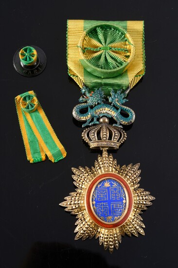 ORDER OF THE DRAGON OF ANNAM (Indochina). Officer's star, in vermeil, gold and enamel, with rosette ribbon in green and yellow moiré silk taffeta. A collar rosette and the ribbon of the miniature decoration are attached. Good condition.H. : 8 cm -...