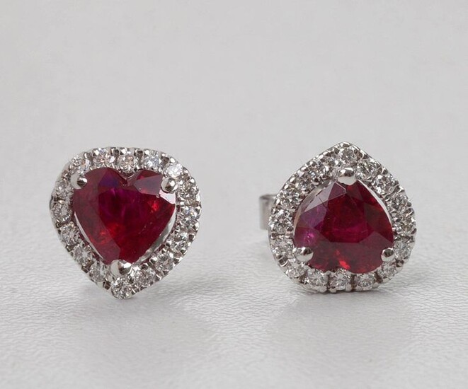 Pair of 18 karat white gold earrings set with two heart cut rubies for a total of +/-1.54 carats (colour: "pigeon's blood") and brilliant-cut diamonds for a total of +/-0.28 carat (Colour: E-F; Purity VS). Size: +/-0.9x0.9cm. Total weight: +/-1.9 gr.
