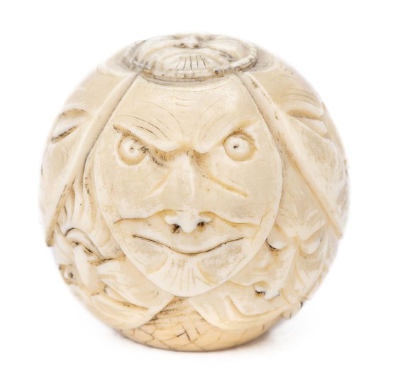 Pommeau de canne en ivoire en forme de sphère figurant des masques de No.