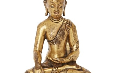Property of a Gentleman (Lots 55-80) A Sino-Tibetan gilt bronze figure of Shakyamuni Buddha, 17th/18th century, cast seated in dhyanasana on a double lotus base, with right hand in bhumisparsa mudra, the left hand resting in the lap, draped in a...