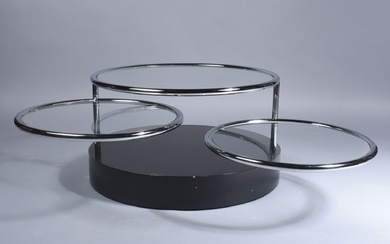 Table basse circulaire modulable à trois plateaux vitrés. Sur une base en plinthe laquée noire,...