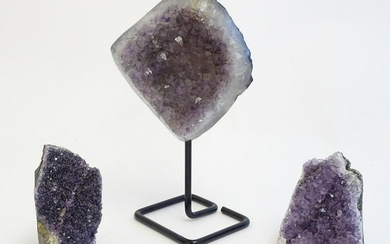 Three amethyst crystal geodes, one with polished edges
