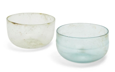 Two Roman glass hemispherical bowls, one cracked, Circa 4th Century A.D. Thin-walled with pronounced omphalos, 5.5cm high max (2) Provenance: UK auction, acquired in May 2018; previously acquired in the late 19th century by a UK missionary and...