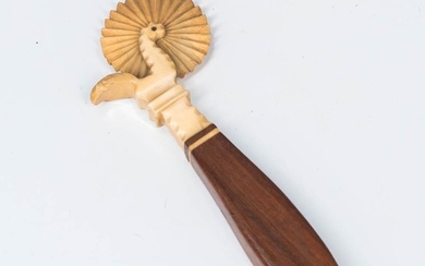 Carved Whale's Tooth and Mahogany Jagging Wheel, mid-19th century, the wheel on a bird-form axle with mahogany handle, (repair), lg. 6