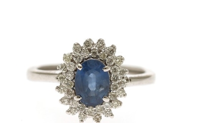 A sapphire and diamond ring set with an oval-cut sapphire weighing app. 1.01 ct. encircled by numerous brilliant-cut diamonds, mounted in 14k white gold.Size 52