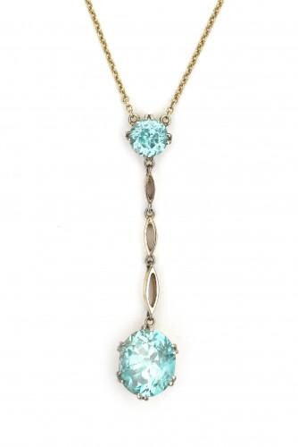 A 14 carat gold negligé blue zircon necklace, ca. 1900. Featuring two blue natural zircons, one round cut zircon of ca. 2 ct. and one oval cut zircon of ca. 7 ct. The setting is done in 18 carat gold, the necklace of 15 carat gold. Gross weight: 6.3 g.