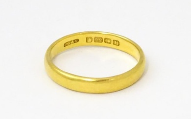 A 22ct gold ring / wedding band. Ring size approx. L 1/2 Please Note - we do not make reference to