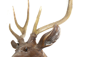 A BLACK FOREST LINDEN WOOD AND ANTLER STAG HEAD...