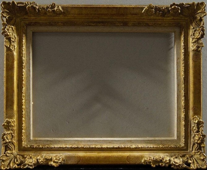A Carved and Gilded Lebrun Style Frame with Décapé Finish, late 19th/early 20th century, with grey painted slip, with plain and leaf sight, the top knull with flower fanned lambrequin and flower corners and hand-tooled reposes, dentil back edge, 59...