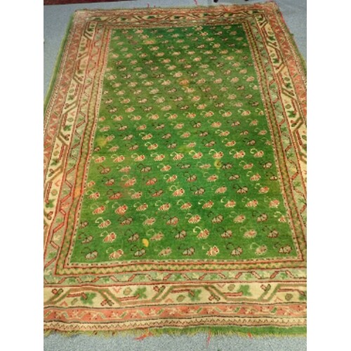 A GREEN GROUND RUG with all-over repeating floral pattern