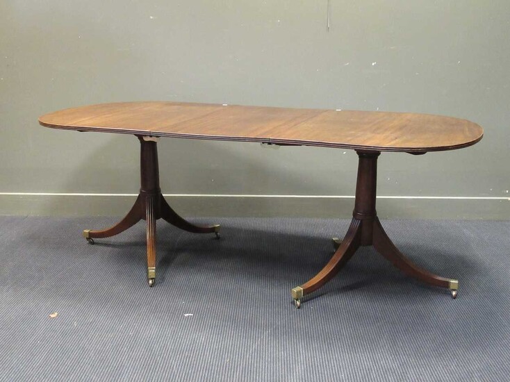 A George III style mahogany twin pedestal dining table with one leaf, early 20th century, the