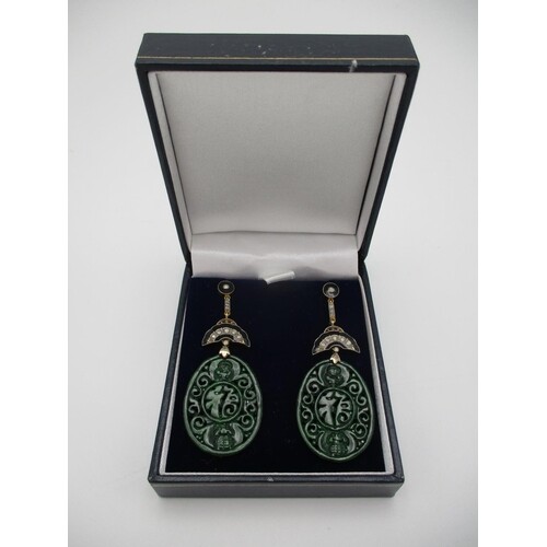 A pair of Asian 9ct gold and silver drop earrings, the carve...