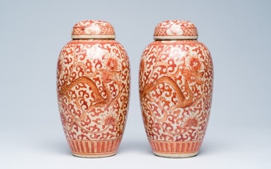 A pair of Chinese crackle glazed iron-red jars and covers with dragons among lotus scrolls, 19th C.