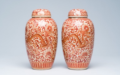 A pair of Chinese crackle glazed iron-red jars and covers with dragons among lotus scrolls,...