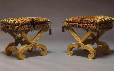 A pair of Continental style giltwood x-framed stools, second half 20th Century, the rectangular leopard print seat, with loose cushion on x frame support with lion mask on inward scrolling feet, (2)