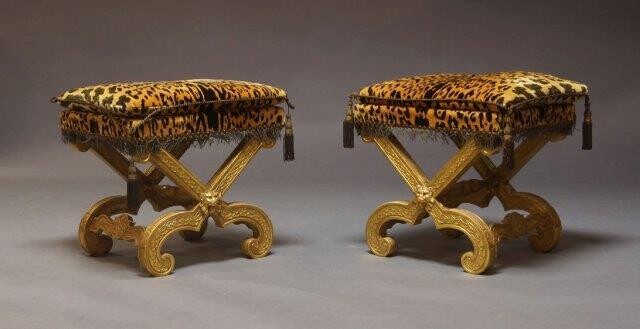 A pair of Continental style giltwood x-framed stools, second half 20th Century, the rectangular leopard print seat, with loose cushion on x frame support with lion mask on inward scrolling feet, (2)