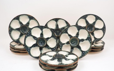 A set of fifteen Majolica oyster dishes, the circular bowls...