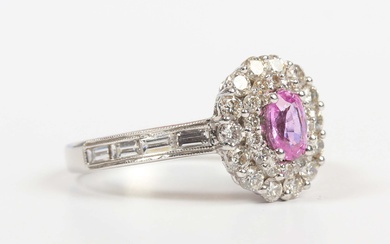 A white gold, pink sapphire and diamond oval cluster ring, claw set with the oval cut pink sapphire
