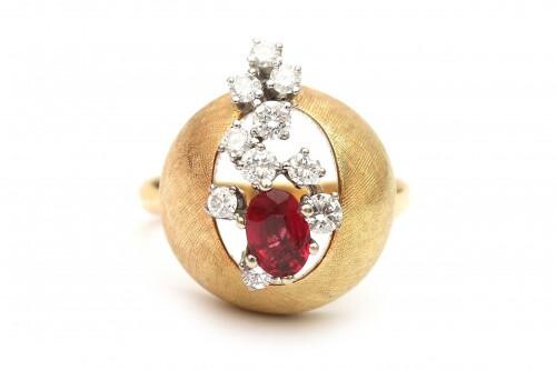 An 18 carat gold diamond and ruby bombé cocktail ring. Designed as a brushed yellow gold ball featuring ten brilliant cut diamonds of ca. 0.40 ct. in total, ca. G-H, ca VS and an oval cut ruby of ca. 0.50 ct. in the center. Gross weight: 14.3 g.