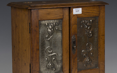 An Edwardian oak smoker's cabinet with inset pressed copper door panels, height 31cm, width 34c