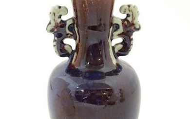 An Oriental twin handled vase, the handles with foliate
