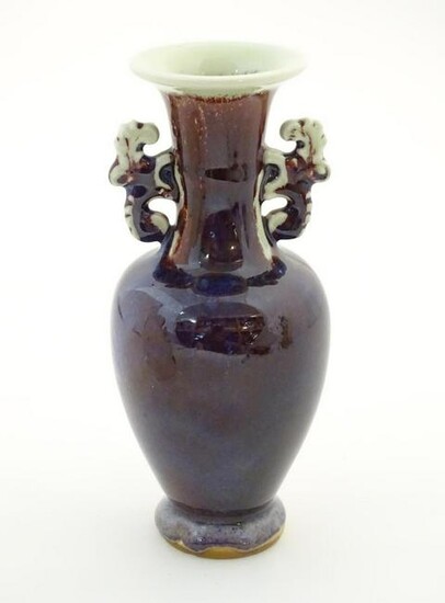 An Oriental twin handled vase, the handles with foliate