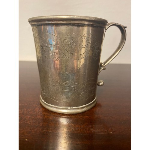 An antique provincial metal mug, with floral decoration and ...
