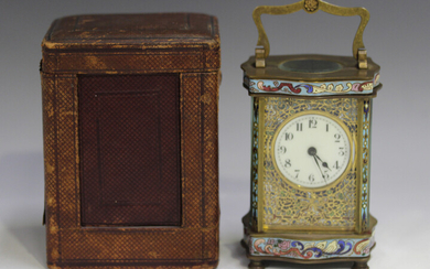 An early 20th century French brass and champlevé enamel serpentine cased carriage timepiece wit