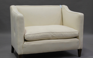 An early 20th century two-seat wing back settee, upholstered in calico, on square tapering block leg