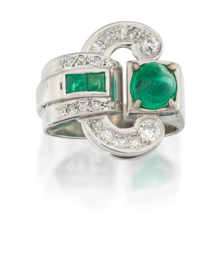 An emerald and diamond dress ring, of stylised buckle design set to one side with a single sugar loaf emerald with pave diamond scrolls and opposing diamond and calibre emerald detail, stamped 750, approx. ring size N