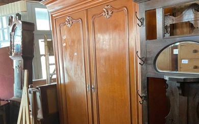 An oak armoire with moulded cornice and carved doors, on...