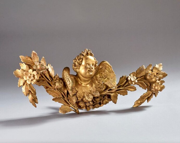 Carved and gilded wooden element depicting a winged angel and a leafy branch.