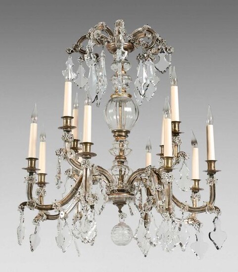 Chandelier with four bunches of three branches of lights in gilded metal dressed in glass. It is decorated with cut crystal plates.
